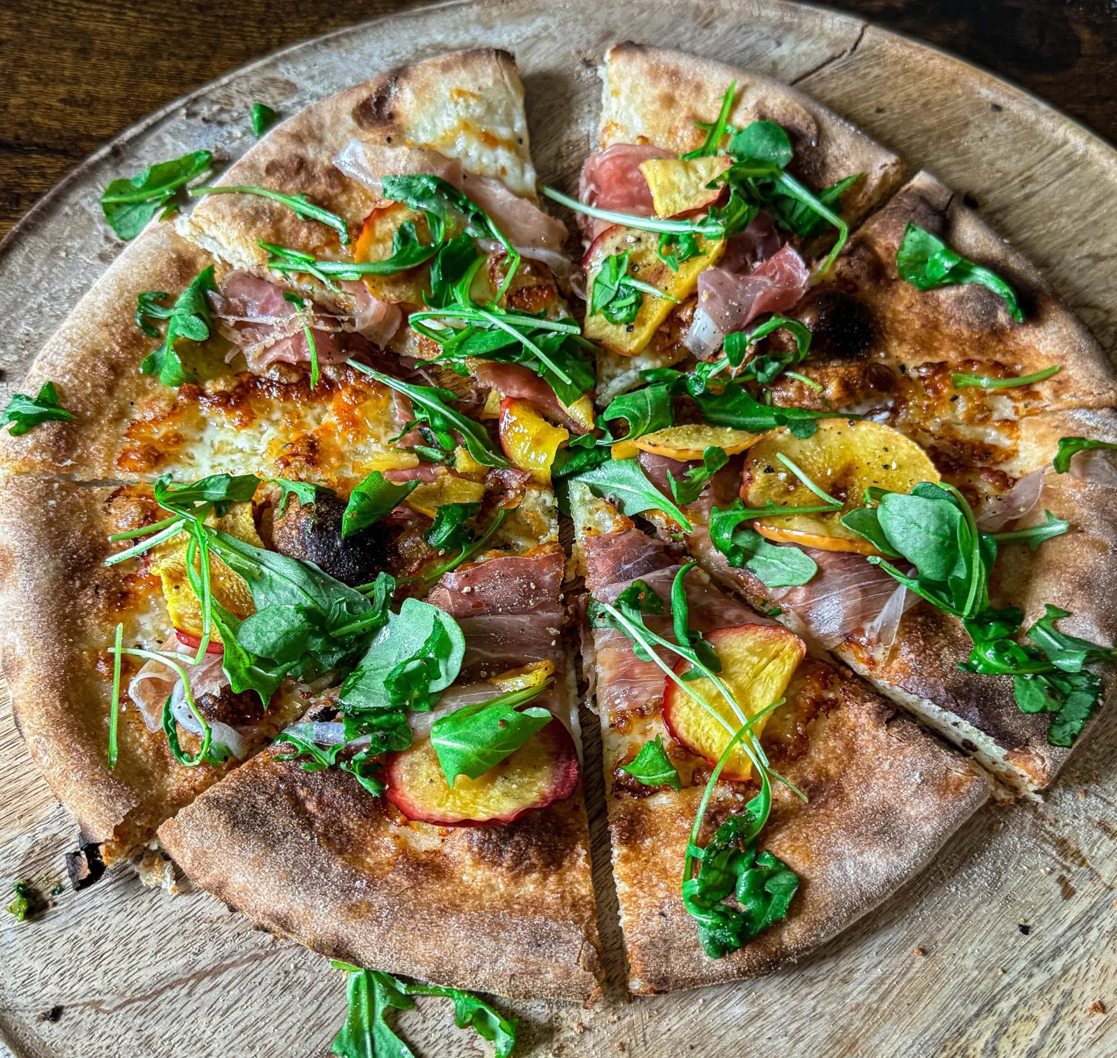 Pizza perzik met fior di latte, parmaham, ruccola en honing